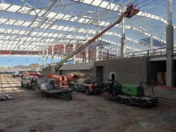 ABlast crew and equipment working among the Fire and Ice Arena steel structure